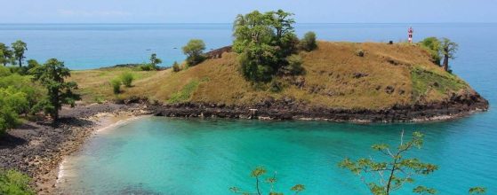 Crystal-clear, turquoise water of Lagoa Azul (Blue Lagoon) in São Tomé, surrounded by rocky terrain and baobab trees. Essential stop on a São Tomé 7-day itinerary for snorkeling.